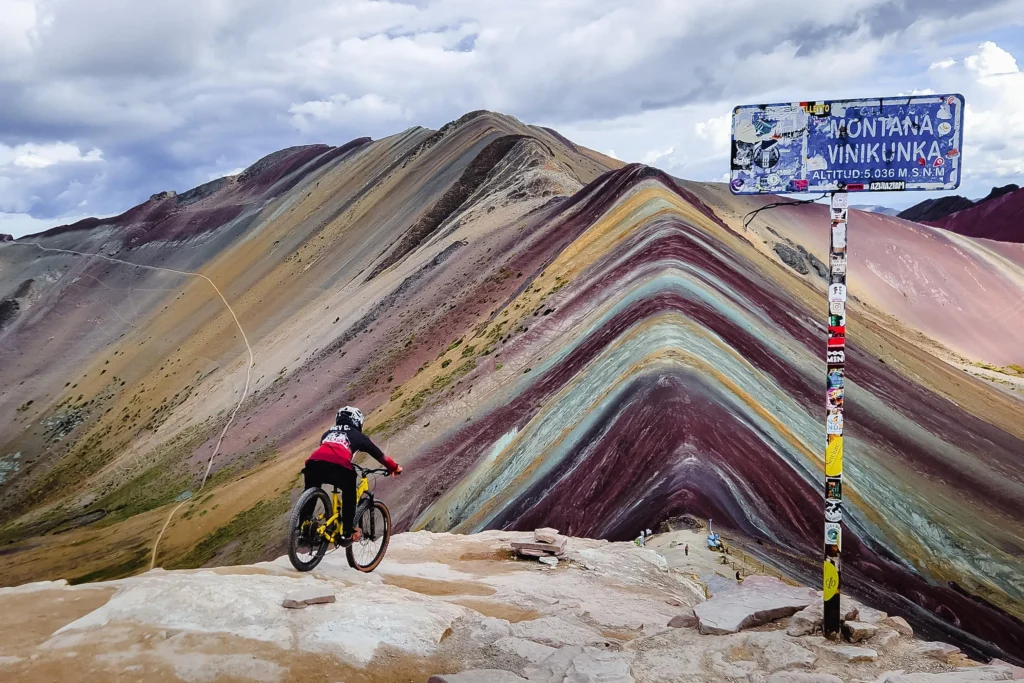 Mountain biker at the top of Rainbow Mountain (Vinicunca)
